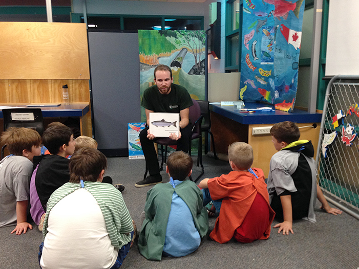 An SNC employee teaches a group of children about fish and water protection in the Stream of Dreams Program.